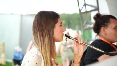 MOSCOW, Rusya - 27 Temmuz 2019: nargile içen genç seksi kadın. Nefes al, nefes ver. 4K video.