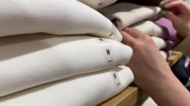 Alışveriş merkezinde kıyafet seçen bir kadın. Kadın deposu.