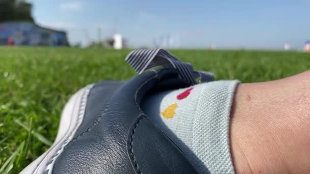Жіночі ноги в кросівках камери на засвіченій зеленій траві, крупним планом . — стокове відео