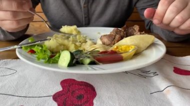 Adam restoranda patates püresi ve ızgara et yiyor. Yakın çekim..
