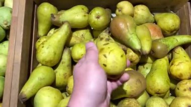 Erkek süpermarketten taze organik armut seçiyor..