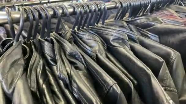 Jaquetas de couro baratos na loja. Casacos estão pendurados para venda. — Vídeo de Stock