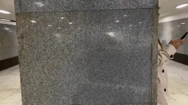 Genç bir kadın alt geçitte akıllı telefon kullanıyor..