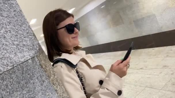 Молодая женщина использует смартфон в подземке. — стоковое видео