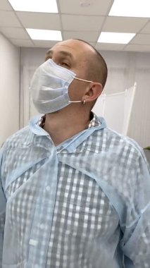 Maskeli genç doktorun dikey görüntüleri. Erkek doktorun yakın plan portresi.