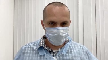 Klinikte tıbbi maskeli bir erkek doktorun portresi..