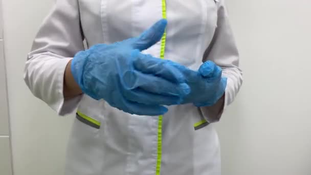 Lekarz lub pielęgniarka zakładający niebieskie rękawice chirurgiczne z nitrylem, profesjonalne bezpieczeństwo medyczne. — Wideo stockowe