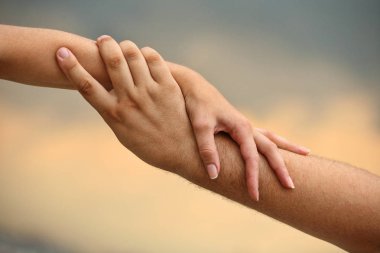 Erkek ve kadın eli gökyüzünün arka planında