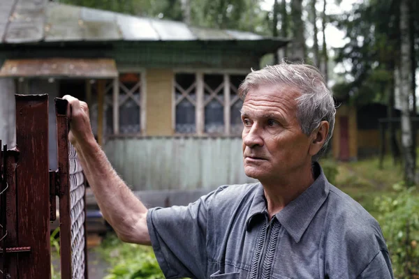 Senior man on a background of an old house — Stock Photo, Image