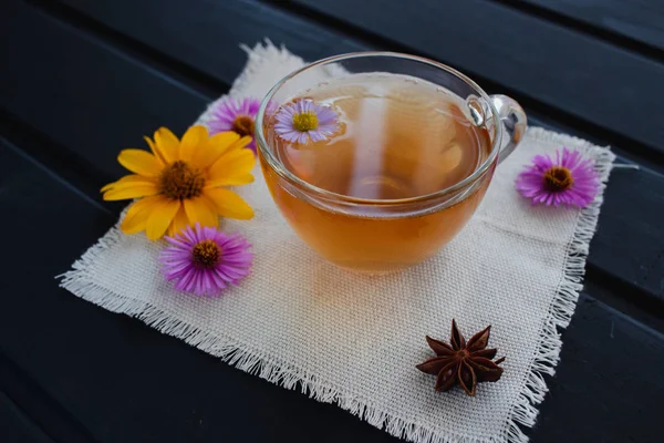 黒いテーブルの上の透明なガラスのカップに花茶。癒し茶. — ストック写真