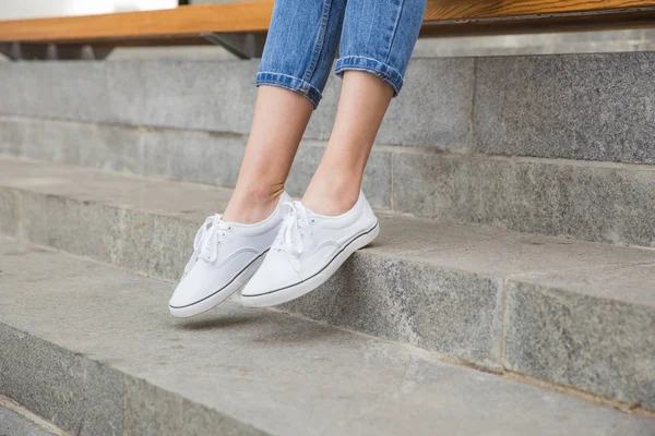 Woman in blue jeans and white textile sneakers — Stock Photo, Image