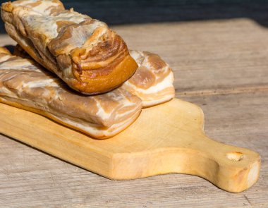 Soğuk tütsülenmiş domuz eti masada.