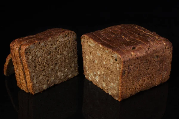Pão Comum Com Grãos Gergelim Cortados Pedaços Sobre Fundo Preto — Fotografia de Stock