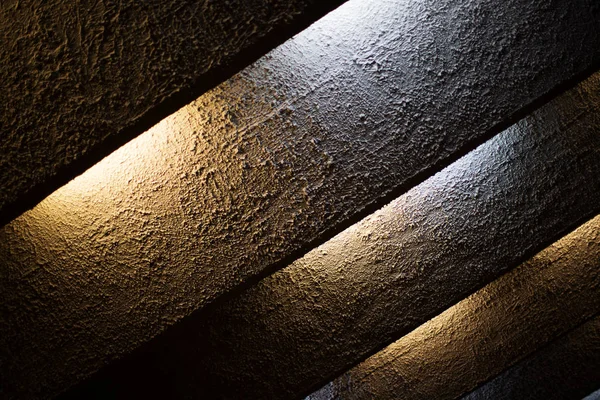 The texture of roughly plastered strips of light-lit electric bulbs