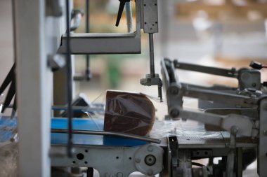 Fırın ürünlerinin paketlenmesi için sanayi hattı. Fabrikada ekmek paketlemek. Ekmek üretimi için bir fabrikayı kesip paketlemek için kullanılan makine..