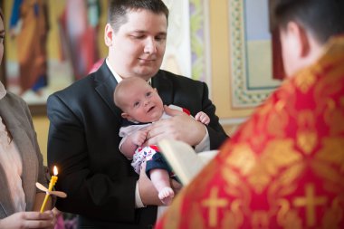 Beyaz Rusya, Gomel, 6 Mayıs 2018. Kilise Volotovo. Yeni doğan bir çocuğun vaftiz. Godfather Ortodoks vaftiz elinde neşeli bir bebek tutan