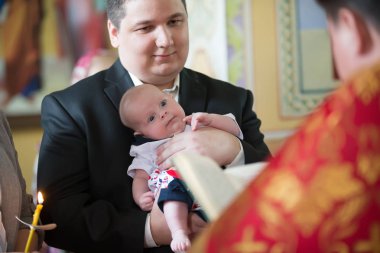 Beyaz Rusya, Gomel, 6 Mayıs 2018. Kilise Volotovo. Yeni doğan bir çocuğun vaftiz. Godfather Ortodoks vaftiz elinde bir bebek tutan