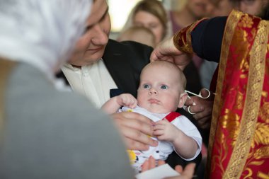 Beyaz Rusya, Gomel, 6 Mayıs 2018. Kilise Volotovo. Yeni doğan bir çocuğun vaftiz. Bir çocuğun vaftiz. Bebek vaftiz için saç kesme. Kilisede değil. Din kabul. Tonsure