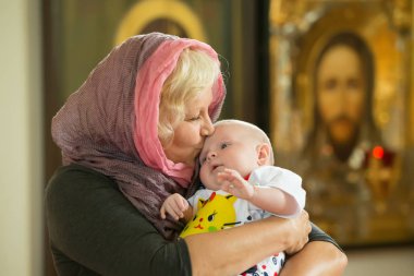 Beyaz Rusya, Gomel, 6 Mayıs 2018. Kilise Volotovo. Yeni doğan bir çocuğun vaftiz. Büyükanne bir eşarp ve yenidoğan kilisede