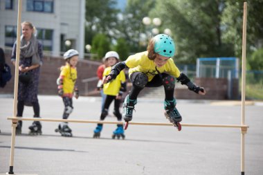 Beyaz Rusya, Gomel, 24 Haziran 2018. Central Park. Çocuk yarışmada silindir spor. Kız silindirler bir halter üzerinden atlar