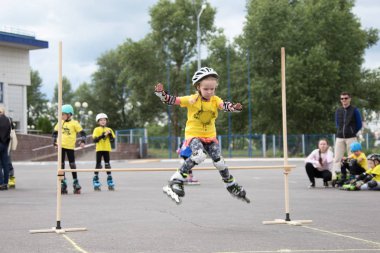 Beyaz Rusya, Gomel, 24 Haziran 2018. Central Park. Çocuk yarışmada silindir spor. Kız silindirler bir halter üzerinden atlar