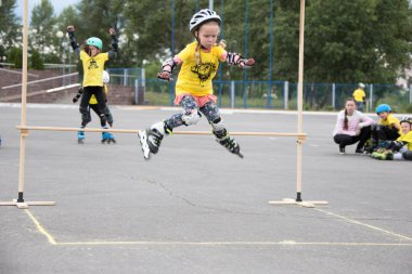 Beyaz Rusya, Gomel, 24 Haziran 2018. Central Park. Çocuk yarışmada silindir spor. Kız silindirler bir halter üzerinden atlar