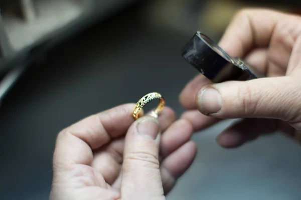Industrial manufacture of the gold ring.Working hands make a gold decoration