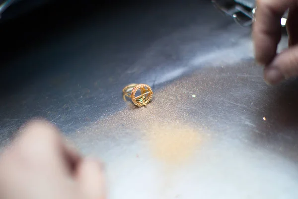 Industrial manufacture of the gold products. Gold ring with dust on the industrial table