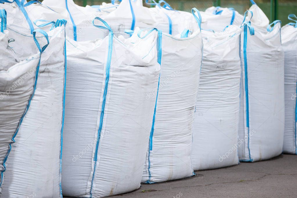 Large white bags.Polyethylene large bags filled with building material