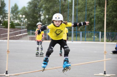 Beyaz Rusya, Gomel, 24 Haziran 2018. Central Park. Çocuk yarışmada silindir spor. Kız silindirler bir halter üzerinden atlar