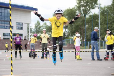 Beyaz Rusya, Gomel, 24 Haziran 2018. Central Park. Çocuk yarışmada silindir spor. Silindirler gurl halter atladı