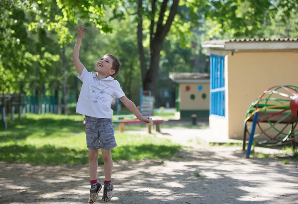 幼稚園の男の子は外で遊ぶ 赤ちゃんをキャッチ 月バグ — ストック写真