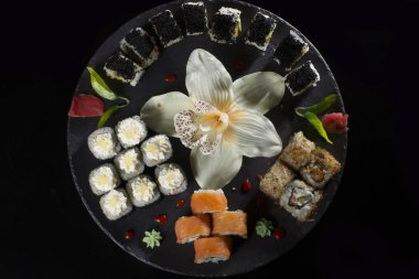 Siyah bir arka plan üzerinde Seth suşi. Japon restoran menü. Birkaç suşi yakın çekimler güzel bir plaka yerleştirilir. Geleneksel Asya gıda