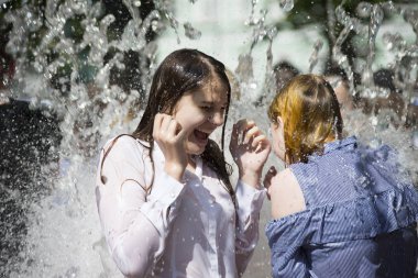 Beyaz Rusya, Gomel şehir, 09 Mayıs 2018. Zafer bayramı kutlaması. Park. Su jetleri altında kız. Havuza yüzmek. Yağmur altında güzel kadın