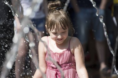 Beyaz Rusya, Gomel şehir, 09 Mayıs 2018. Zafer bayramı kutlaması. Park. Su jetleri altında kız. Havuza yüzmek. Adam su damlaları altında