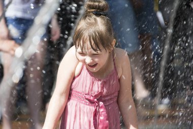 Beyaz Rusya, Gomel şehir, 09 Mayıs 2018. Zafer bayramı kutlaması. Park. Su jetleri altında kız. Çocuk Çeşme banyoları. Adam su damlaları altında