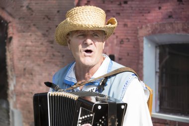 Beyaz Rusya, Gomel şehir, 15 Eylül 2018. Tatil şehri gün. Merkez Park.A adam mızıka çalmaya hasır şapkalı. Harmonist'de