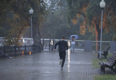 Yağmurda koşan adam. Kötü yağmurlu hava