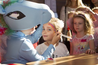 Beyaz Rusya, Gomel, 13 Ekim 2018. Şehir tatil. Çocuk partisi. Animatör yüz boyama çocuk üzerinde koyar.