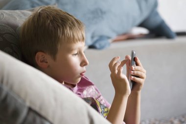Çocuk ile bir cep telefonu. Çocuk okul çağındaki bir gadget ile