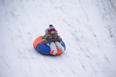Sledding.Happy çocuk tatilde. Kış eğlence ve oyun. Küçük çocuk kızağı binmek zevk. Çocuklar açık havada karda oynamak. Çocuklar kızak kış Alp dağlarında