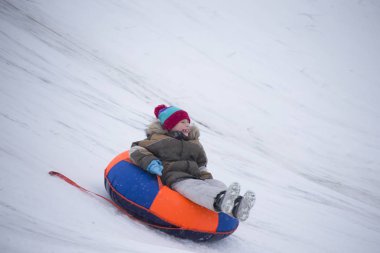 Sledding.Happy çocuk tatilde. Kış eğlence ve oyun. Küçük çocuk kızağı binmek zevk. Çocuklar açık havada karda oynamak. Çocuklar kızak kış Alp dağlarında