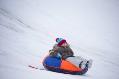 Sledding.Happy çocuk tatilde. Kış eğlence ve oyun. Küçük çocuk kızağı binmek zevk. Çocuklar açık havada karda oynamak. Çocuklar kızak kış Alp dağlarında