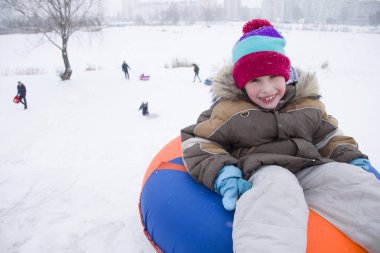 Sledding.Happy çocuk tatilde. Kış eğlence ve oyun. Küçük çocuk kızağı binmek zevk. Çocuklar açık havada karda oynamak. Çocuklar kızak kış Alp dağlarında