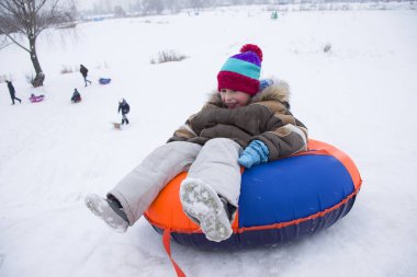 Sledding.Happy çocuk tatilde. Kış eğlence ve oyun. Küçük çocuk kızağı binmek zevk. Çocuklar açık havada karda oynamak. Çocuklar kızak kış Alp dağlarında