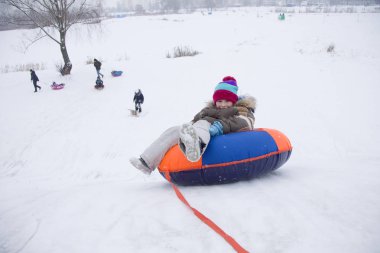 Sledding.Happy çocuk tatilde. Kış eğlence ve oyun. Küçük çocuk kızağı binmek zevk. Çocuklar açık havada karda oynamak. Çocuklar kızak kış Alp dağlarında
