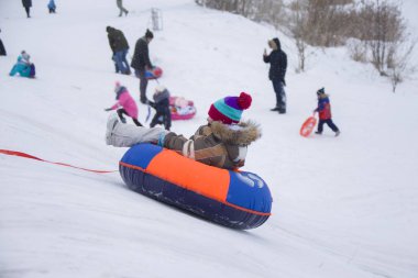 Beyaz Rusya, Gomel şehri, 31 Aralık 2018. Merkez mahalle. İnsanlar kar kaydırağında ata binerler. Çocuk kızak cheesecakes