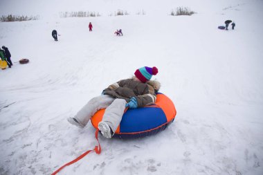 Sledding.Happy çocuk tatilde. Kış eğlence ve oyun. Küçük çocuk kızağı binmek zevk. Çocuklar açık havada karda oynamak. Çocuklar kızak kış Alp dağlarında