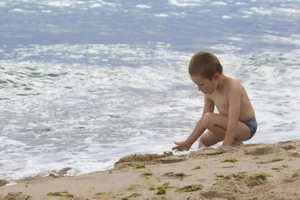 海の近くの砂で遊ぶ少年 リゾートでバカンスの子 — ストック写真