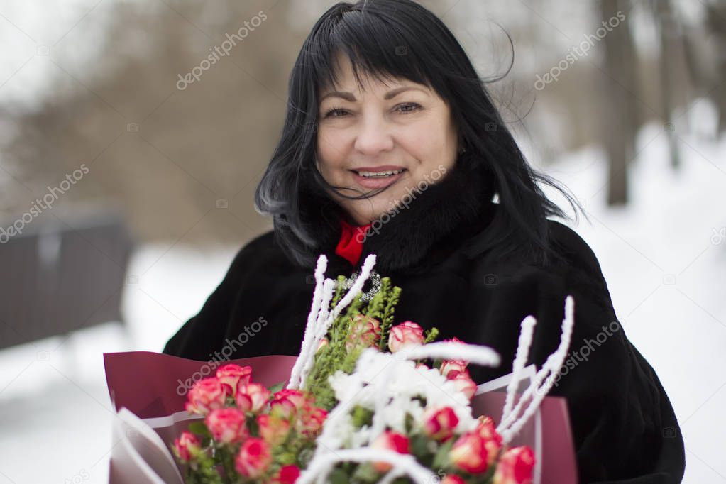 Beautiful elderly woman with a bouquet of flowers